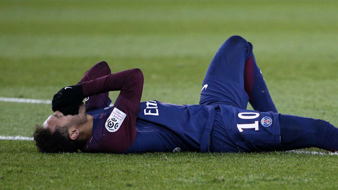 Footballer lying on the ground with hands over his face in disappointment