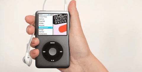 A hand holding an iphone and ear phones