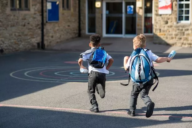 Small children running into school